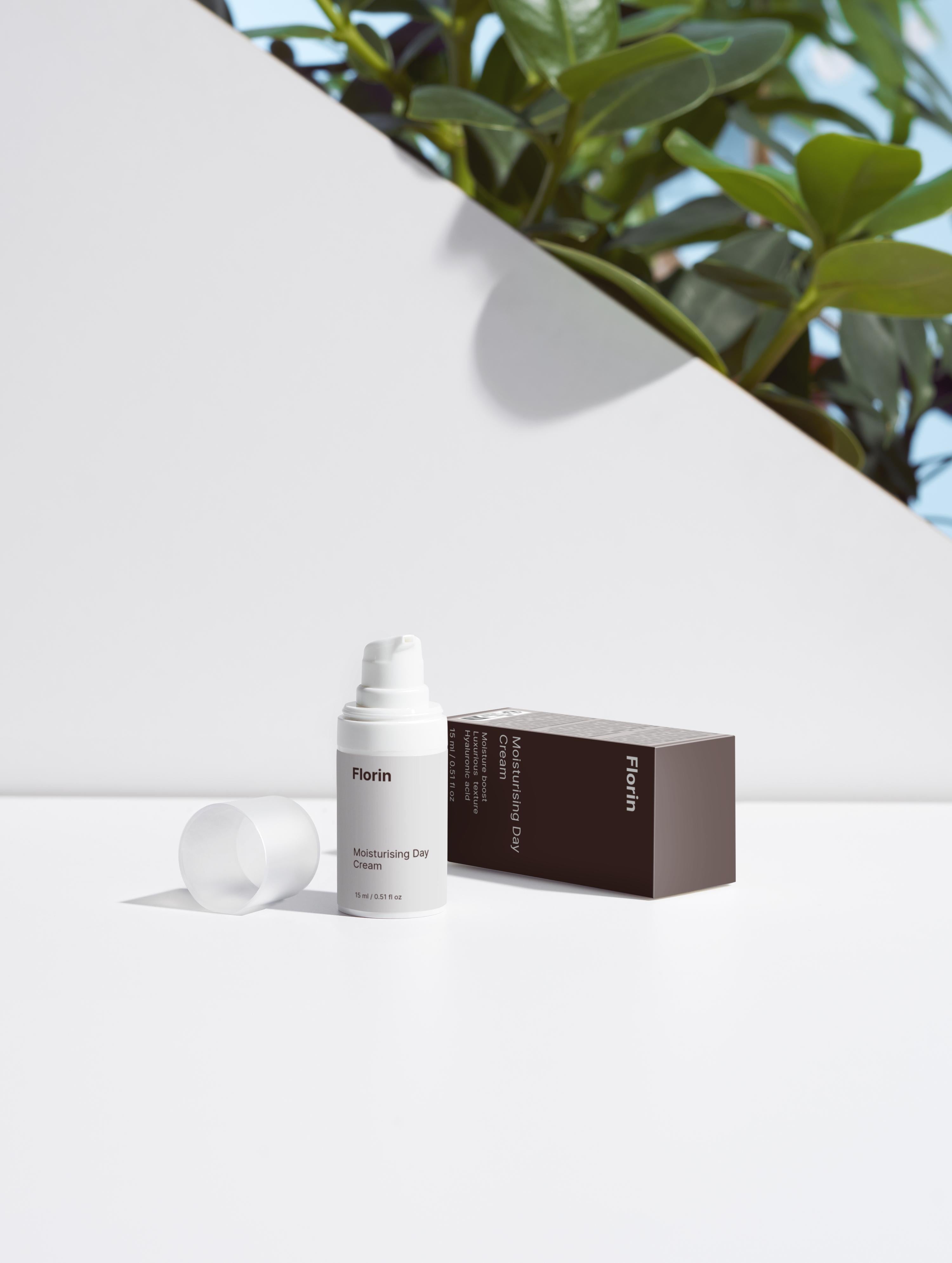 White skincare bottle and box with 'Floris' branding on a white background with greenery.