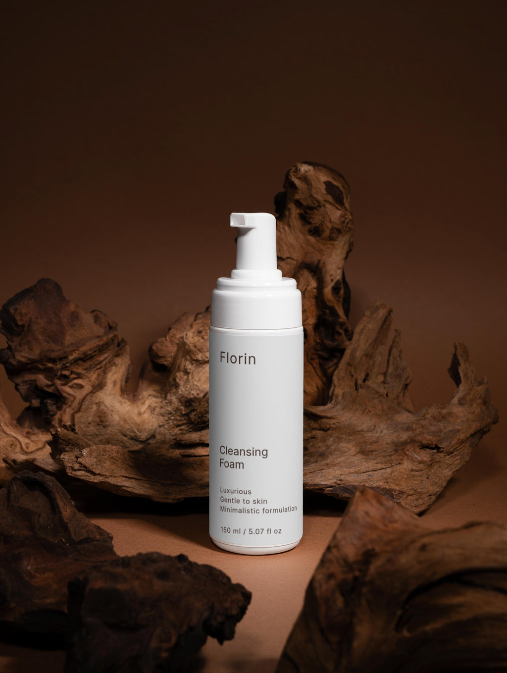 White bottle of Florin Cleansing Foam on a brown background with natural elements.